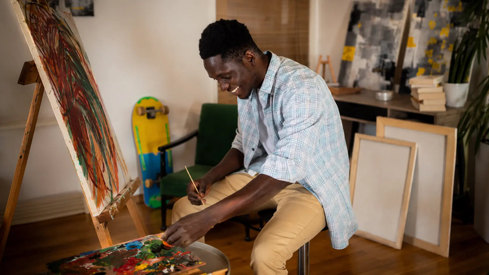 Artiste peignant en atelier sur un chevalet en bois, avec palette et toiles dans un espace créatif lumineux.